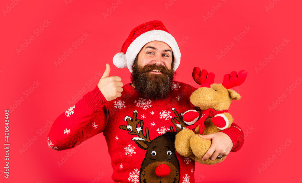 Toys shop. Happy new year. Santa Claus. Symbol of Christmas. Christmas eve. Gifts for kids. Dear Santa. Bearded man reindeer toy. Plush deer. Hipster man hold Christmas gift. Happy man playful mood