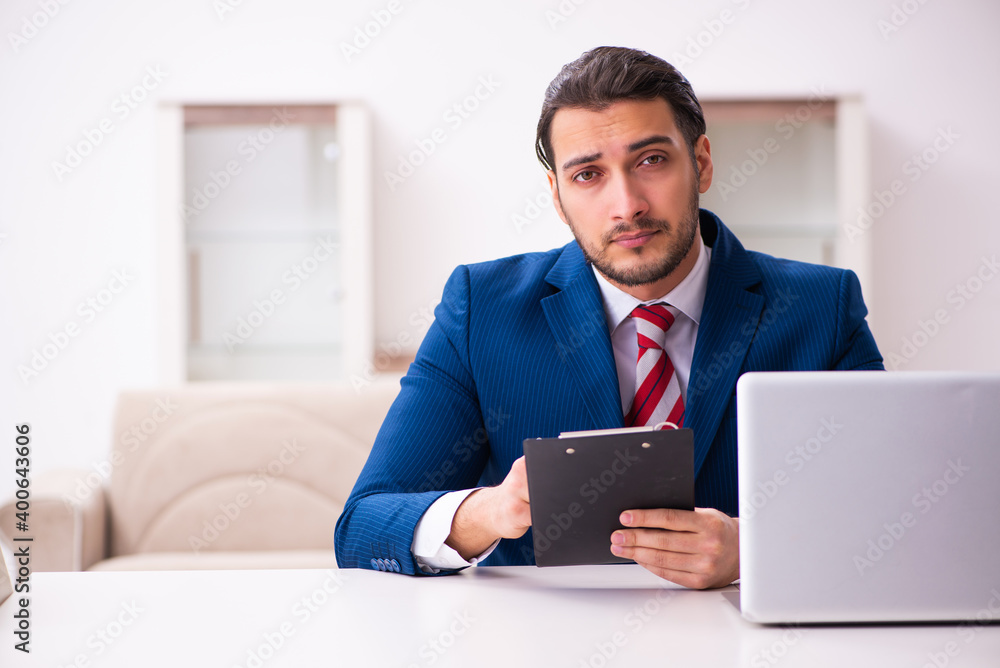 Handsome male realtor working indoors Handsome male realtor working indoors