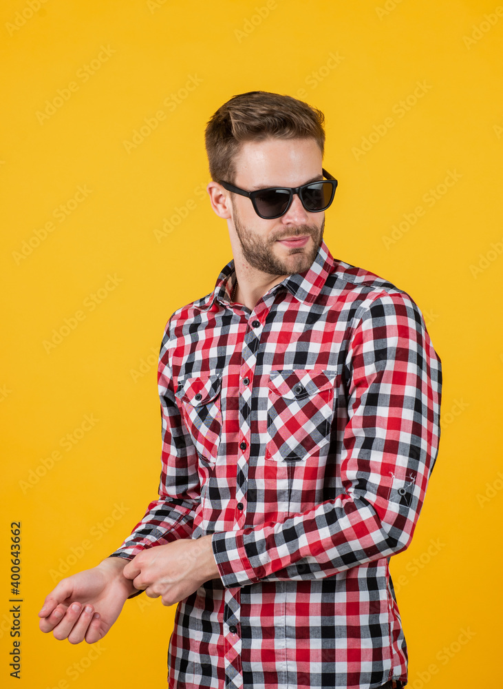 Obraz premium young handsome man in checkered shirt and sunglasses has bristle on face, casual style