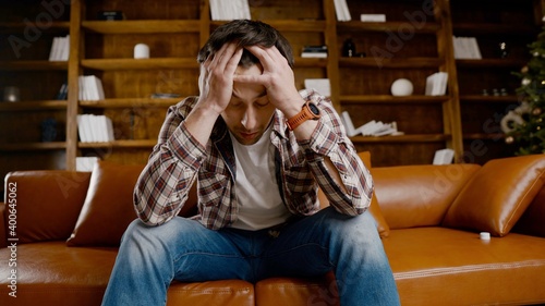 Tableau sur toile Depressed young man drinking alcohol at home