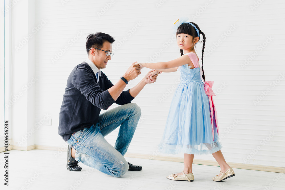 An Asian father and daughter are dancing, dad teaches daughters to dance in a fun room An Asian father and daughter are dancing, dad teaches daughters to dance in a fun room