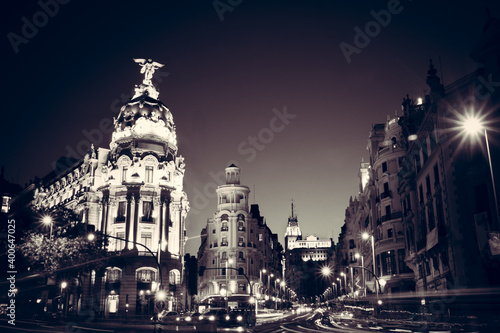 Rays of traffic lights on Gran via street, main shopping street in Madrid at night. Spain, Europe. Monotone image.