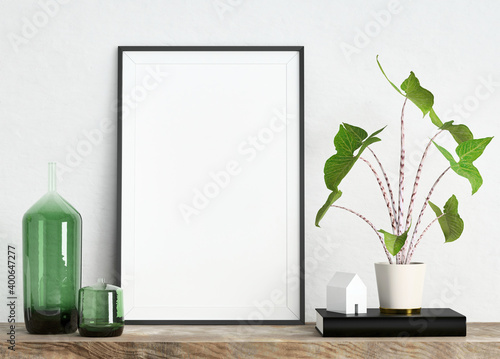 Mock up poster frame on white plaster wall with plant in a pot, house model and glass vases on wooden shelf; portrait orientation; stylish frame mock up background; 3d rendering, 3d illustration