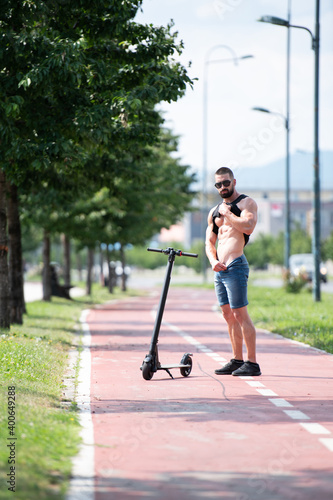 Athlete Posing Near Electric Scooter in City © Jale Ibrak