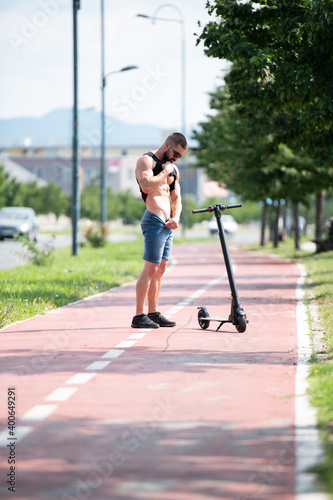 Man Posing Near Electric Scooter