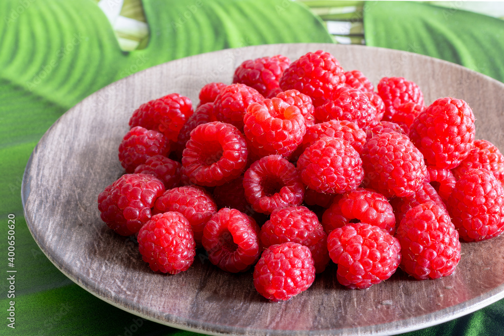 Framboises dans une assiette en bois Framboises dans une assiette en bois