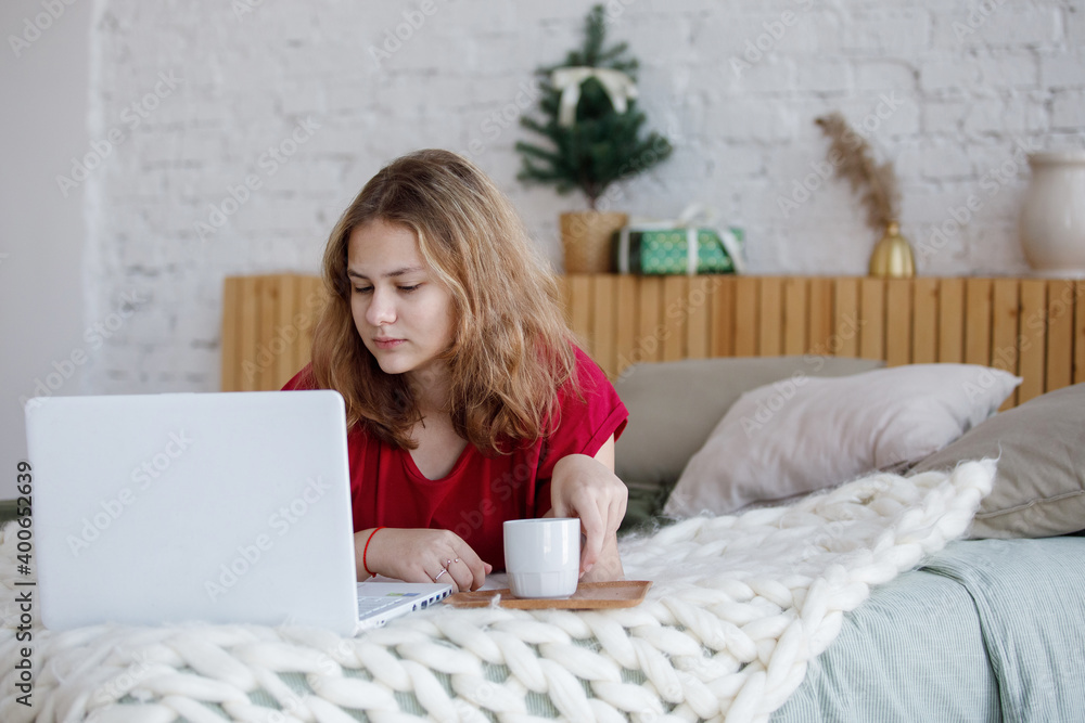 Teen girl in bed with laptop