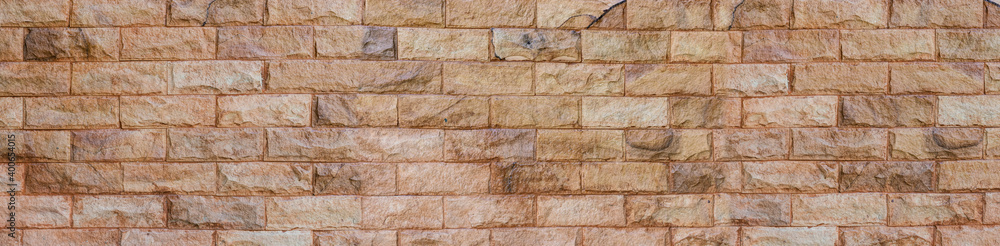 Fototapeta premium Brick wall of colorful color, wide panorama of masonry