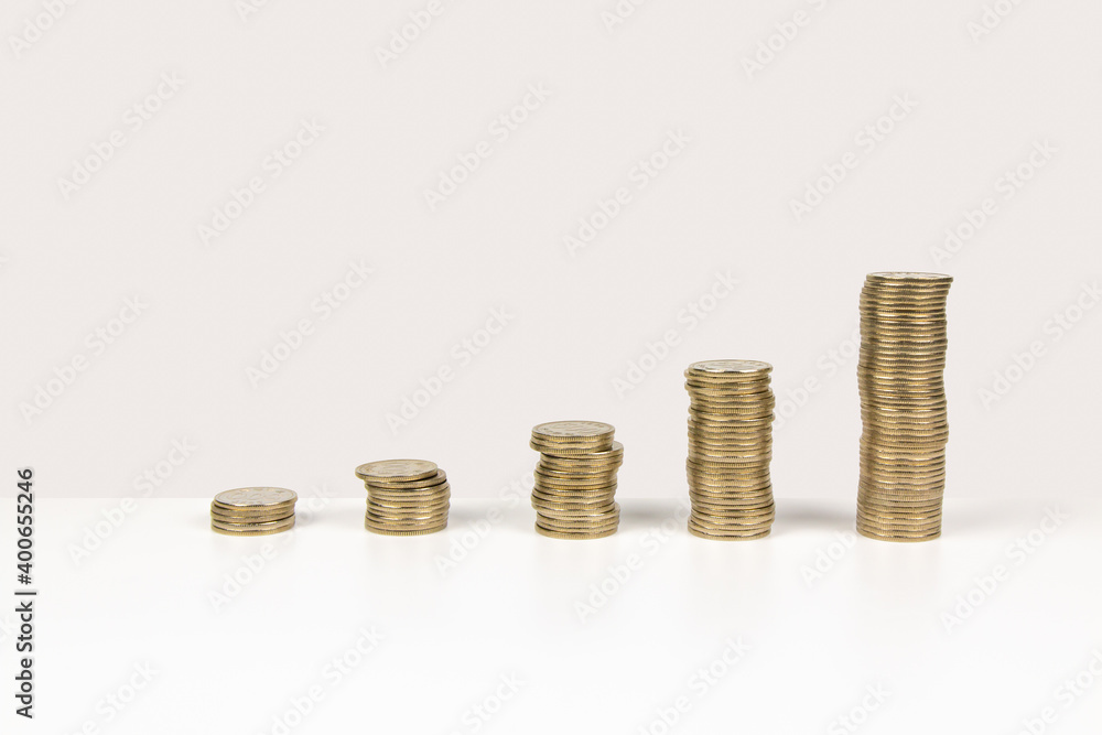 Stack of increasing coins on bright background Stack of increasing coins on bright background