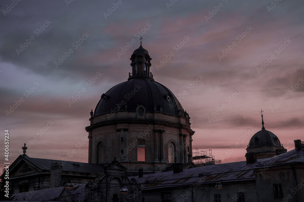 ancient Gothic cathedral dome Europe medieval architecture building urban landmark city view in dramatic evening time with moody sky background space purple gray clouds