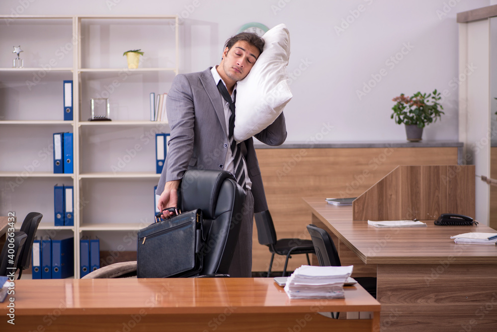 Young male employee sleeping at workplace Young male employee sleeping at workplace