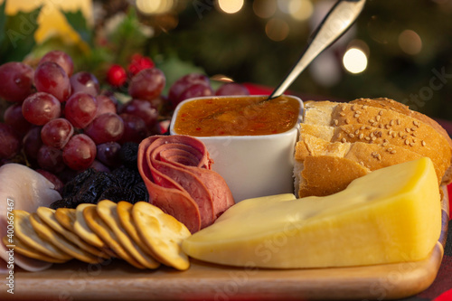 Board with Grape, Cookie, Jam, Bread, Ham, Candle, Pine Cone, Cheese to eat at the Christmas picnic