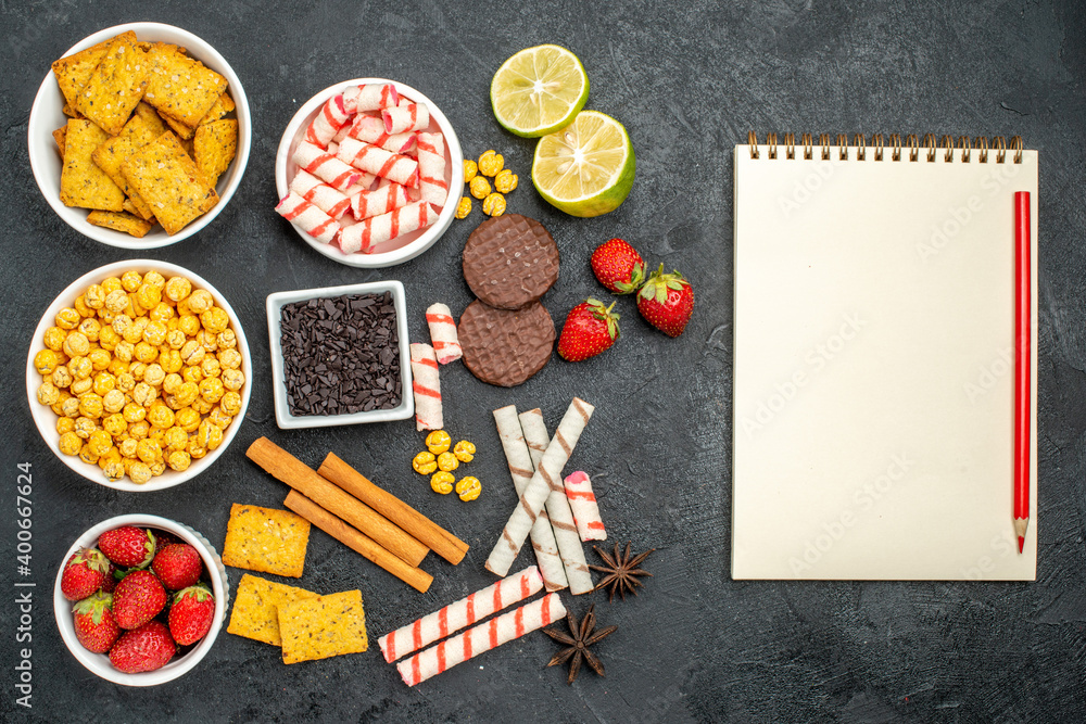 top view panatable snack receipe with fresh lemon and stawberries near to blank notebook pen on the black surface with free space top view panatable snack receipe with fresh lemon and stawberries near to blank notebook pen on the black surface with free space