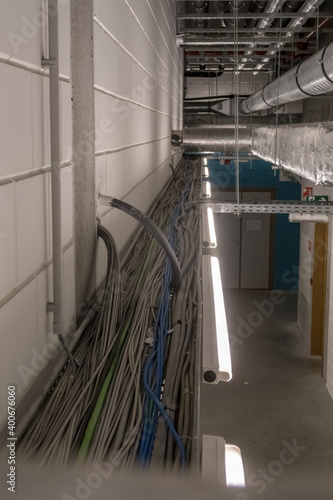 electrical cables hang from the ceiling in a cable duct