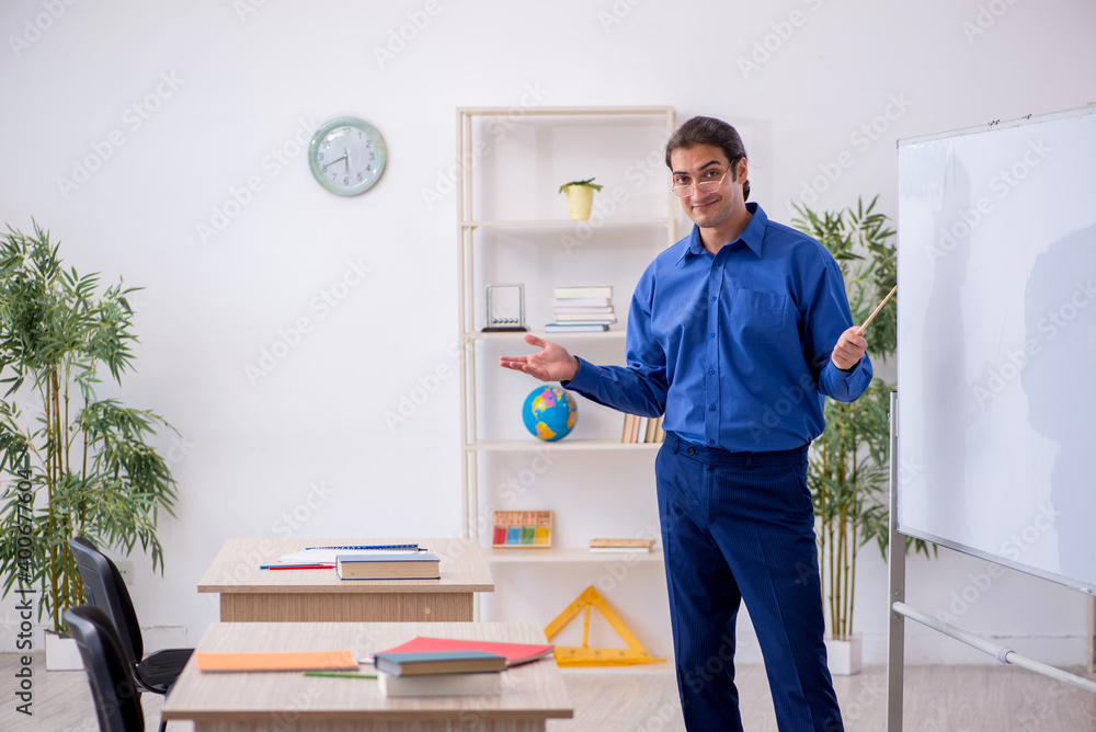 Young male teacher in front of white board