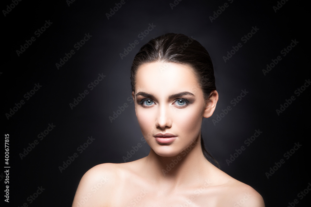Beauty young brunette woman studio portrait with beautiful clean healthy skin, make-up. Dark background Beauty young brunette woman studio portrait with beautiful clean healthy skin, make-up. Dark background