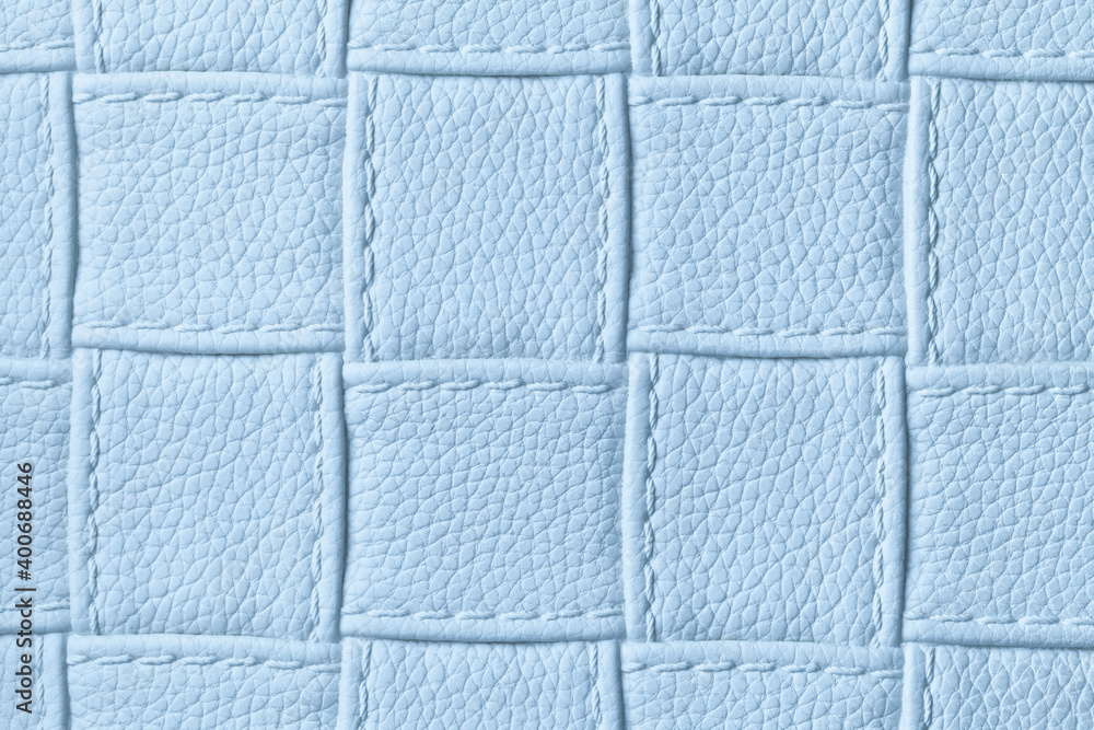 Fototapeta premium Texture of light blue leather background with square pattern and stitch, macro.