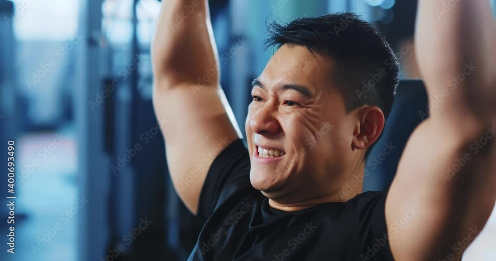 Professional asian sportsman bodybuilder or fitness trainer lifting weights for arms training working out in the gym. Professional asian sportsman bodybuilder or fitness trainer lifting weights for arms training working out in the gym.