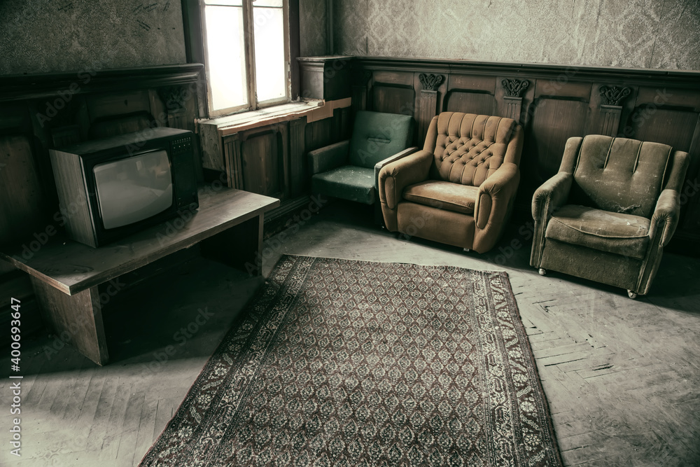 An old room with shabby walls in an abandoned house. Antique TV, chairs and  carpet on the floor. foto de Stock | Adobe Stock