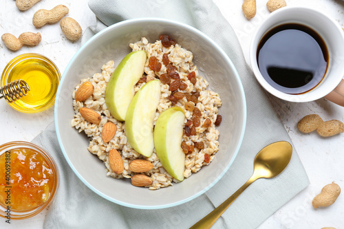 Bowl with tasty sweet oatmeal on table