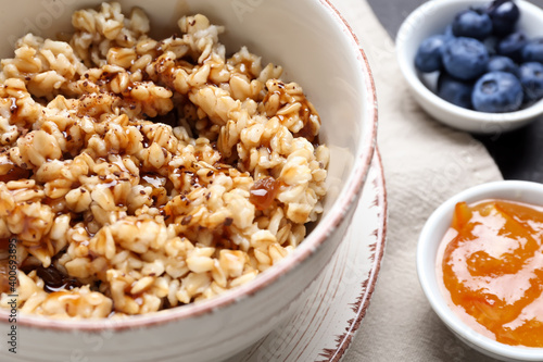 Bowl with tasty sweet oatmeal, closeup