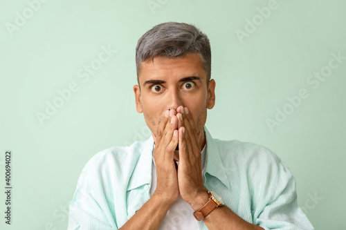Stressed man with graying hair on color background