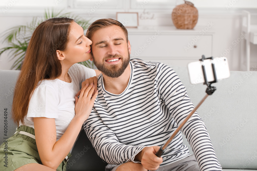 Fototapeta premium Young couple taking selfie at home
