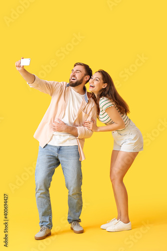 Young couple taking selfie on color background © Pixel-Shot