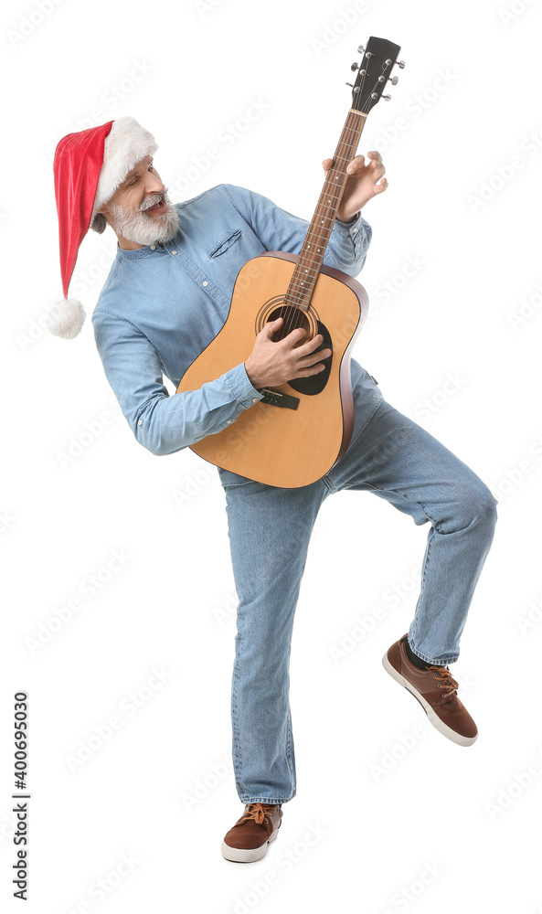 Senior man in Santa hat playing guitar on white background Senior man in Santa hat playing guitar on white background