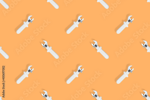 Wrench on an orange background. Seamless background from adjustable metal wrench. Seamless patterns.