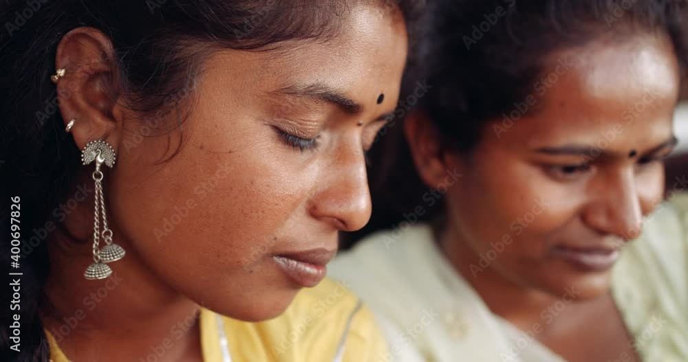 Slow-motion close-up side profile portraits of two women females looking at something seriously with intent and attention together seated together teamwork Slow-motion close-up side profile portraits of two women females looking at something seriously with intent and attention together seated together teamwork