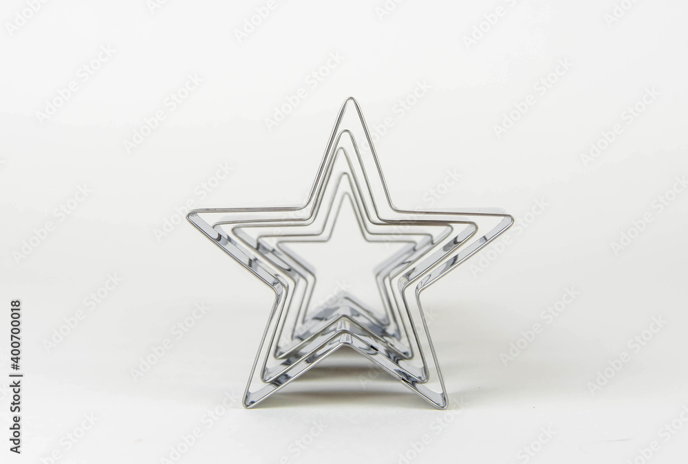 Obraz premium Metal forms for cookies in the shape of a star on a white background in a row.