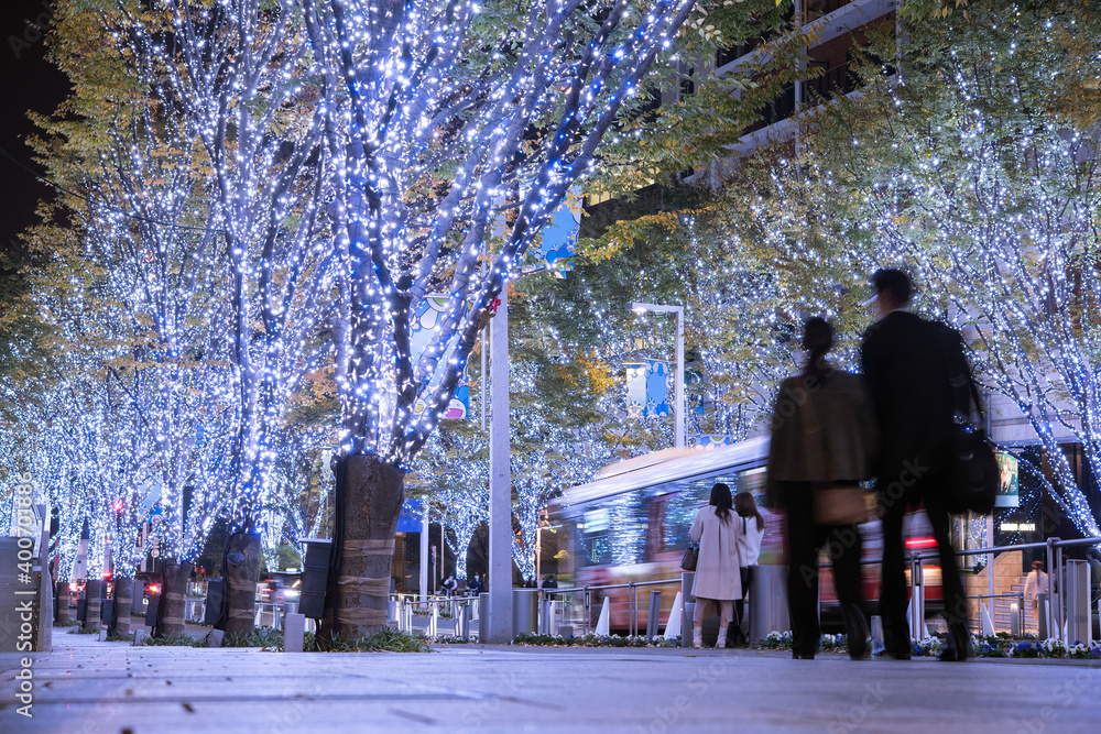 Japanese couple walking on illuminated Roppongi Keyakizaka Street in Tokyo during winter　六本木のけやき坂を歩くカップル 冬の夜を彩るイルミネーション