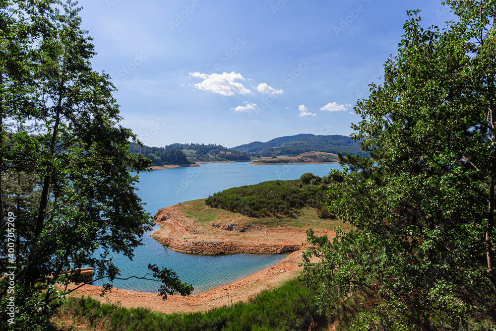 Amazing landscape of alpine lake with crystal clear blue water and perfect blue sky. Panoramic view of beautiful mountain landscape in National Park Of Sila, Calabria