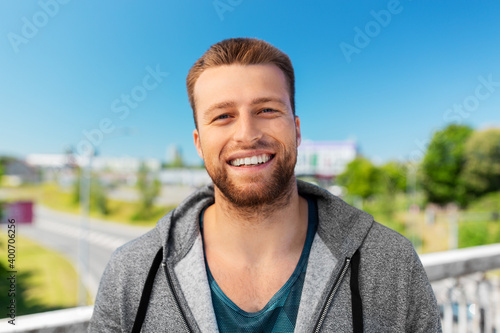 fitness, sport and people concept - portrait of happy smiling young man outdoors