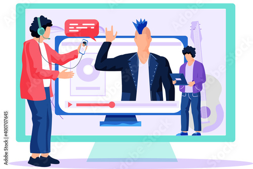 A man in headphones and a red sweater stands near a large screen with a phone in his hands and writes a message for an online broadcast. The monitor displays rocker with his music award and guitar