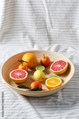 Fototapeta Naklejka Na Ścianę i Meble -  food, healthy eating and vegetarian concept - close up of citrus fruits on wooden plate