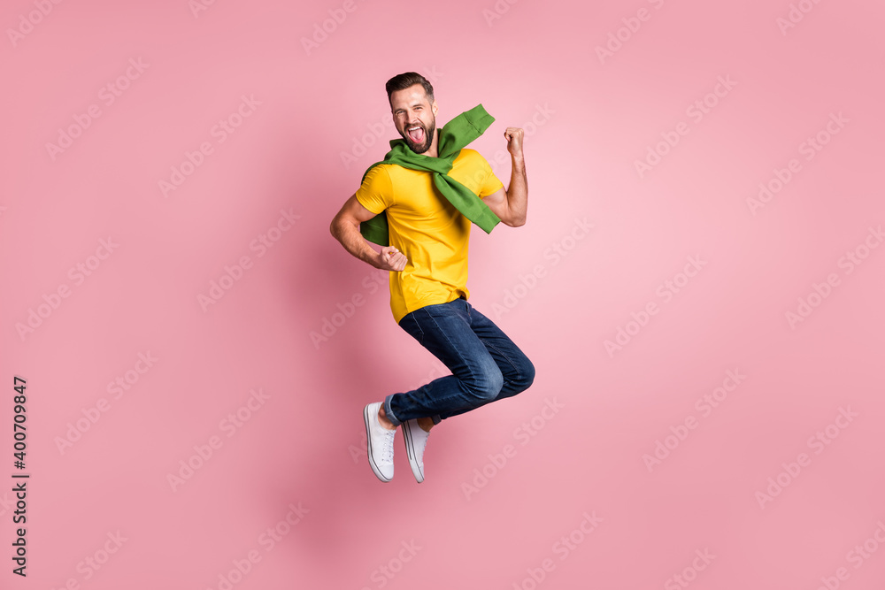 Full size photo of cheerful bearded brown haired man jump air raise fists winner isolated on pastel pink color background