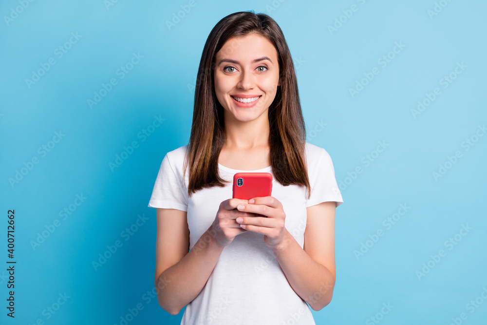 Photo of adorable sweet young lady wear white clothes writing modern gadget isolated blue color background Photo of adorable sweet young lady wear white clothes writing modern gadget isolated blue color background