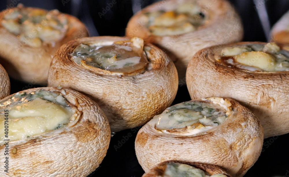 Baked mushrooms stuffed with cheese. Cooking food in the oven at home.