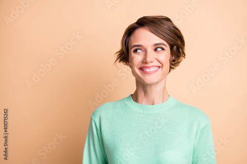Portrait of young positive good mood beautiful charming attractive girl look copyspace isolated on beige color background