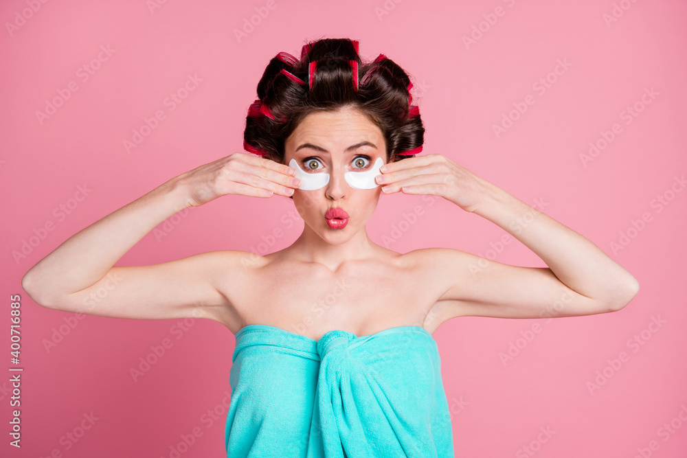 Amazed girl touch face eye patch skin care rejuvenation effect wear blue towel isolated pastel color background