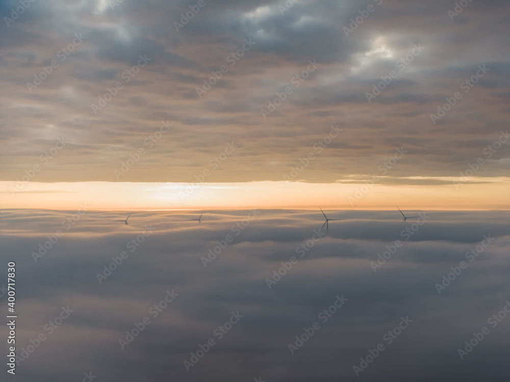 Amanecer con mar de nubes de niebla y molinos eólicos