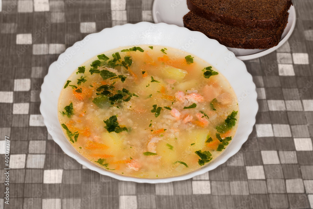 Bowl of clear trout soup on a table
