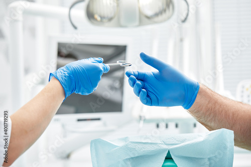 Close-up of the hands of a dentist and nurse surgeon over an operating room during a dental implant operation