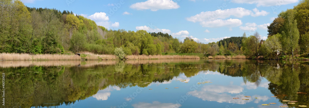 A typical spring rural Lithuanian panoramic landscape wuth  a lake and forest