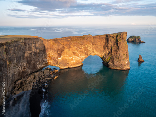 Amazing black arch of lava standing in the sea. Location cape Dyrholaey, Iceland