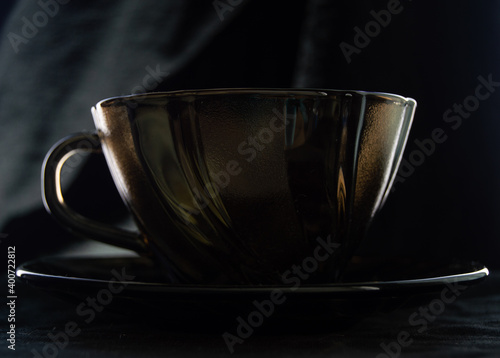 tinted coffee cup on black background with backlight