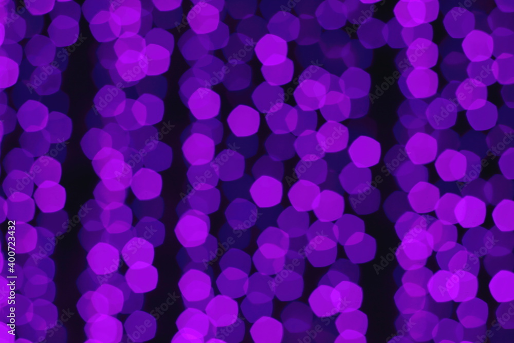 Abstract blurred bokeh of Christmas garland in purple. Defocus.