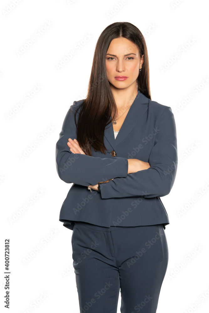 Young serious beautiful business woman in a pants and jacket with arms folded Young serious beautiful business woman in a pants and jacket with arms folded